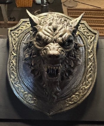 Front view of Dogman bust in ornate shield-shaped frame