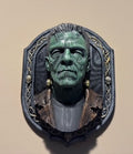 Front view of Frank green monster bust in ornate skull-accented frame