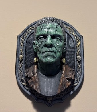Front view of Frank green monster bust in ornate skull-accented frame