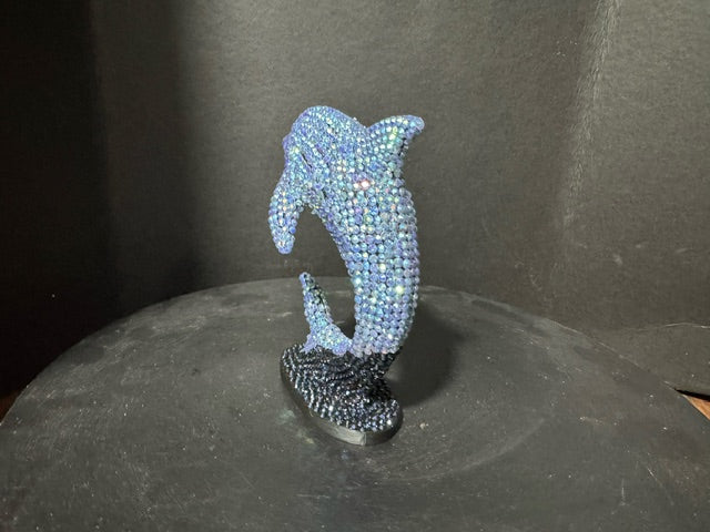 Three-quarter view of beaded dolphin statue showing iridescent blue detail