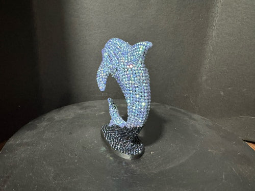 Three-quarter view of beaded dolphin statue showing iridescent blue detail