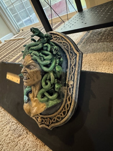 Side view showing the sculptural depth of Medusa and her coiling serpents