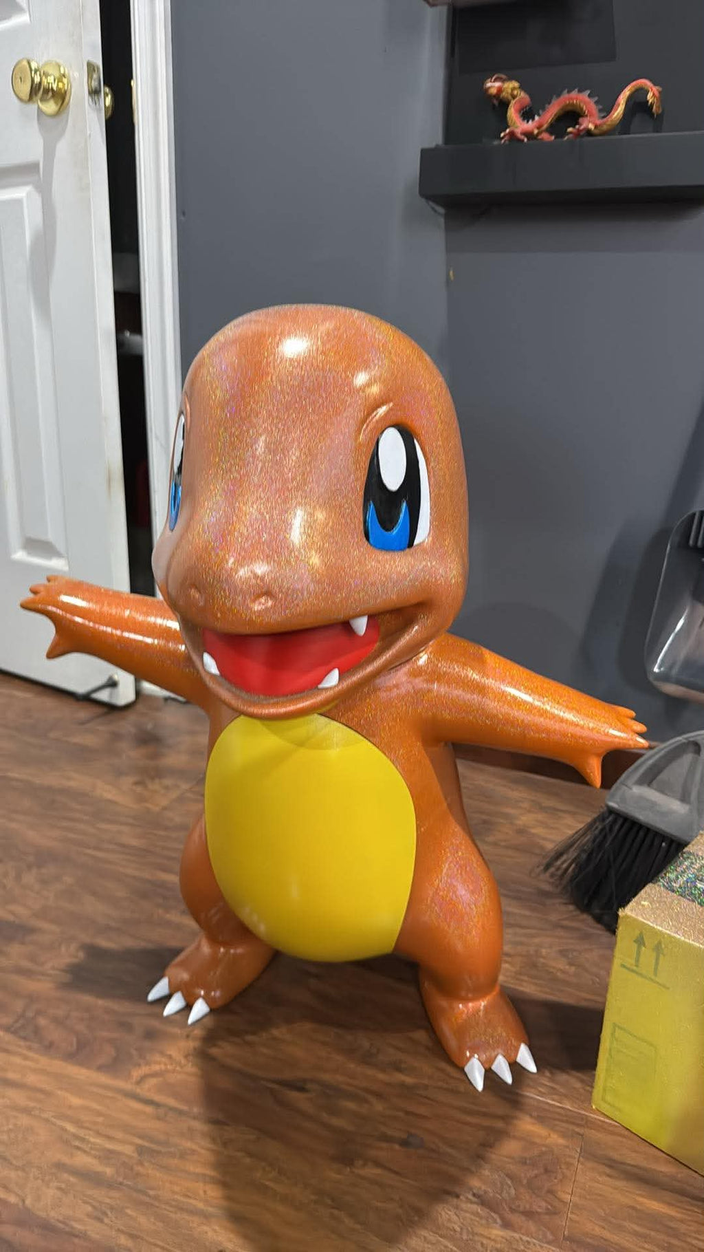 Life-size Charmander 3D printed statue hand painted, front view showing glossy orange finish, blue eyes, yellow belly, and white claws