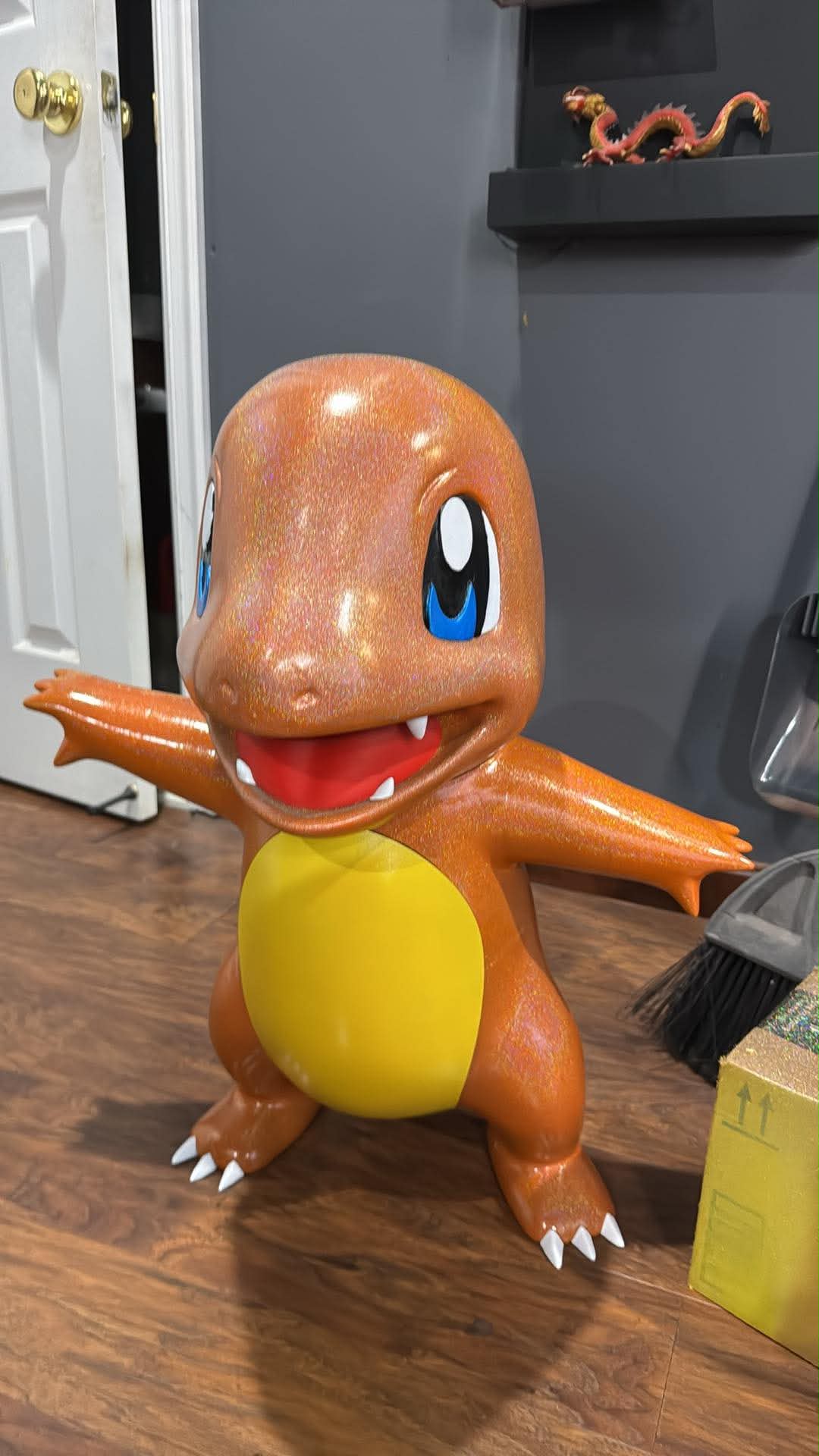 Life-size Charmander 3D printed statue hand painted, front view showing glossy orange finish, blue eyes, yellow belly, and white claws