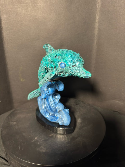 Filigree dolphin statue side view — gem eye detail and wave base